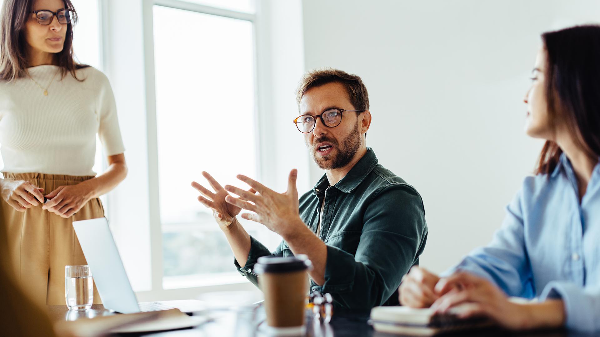Ein Mann diskutiert mit seinen Kolleginnen
