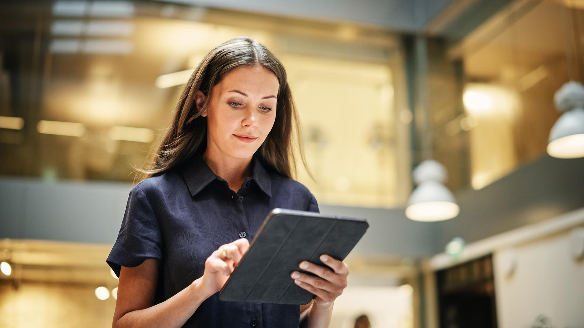 Eine Frau, die konzentriert auf ihr Tablet schaut