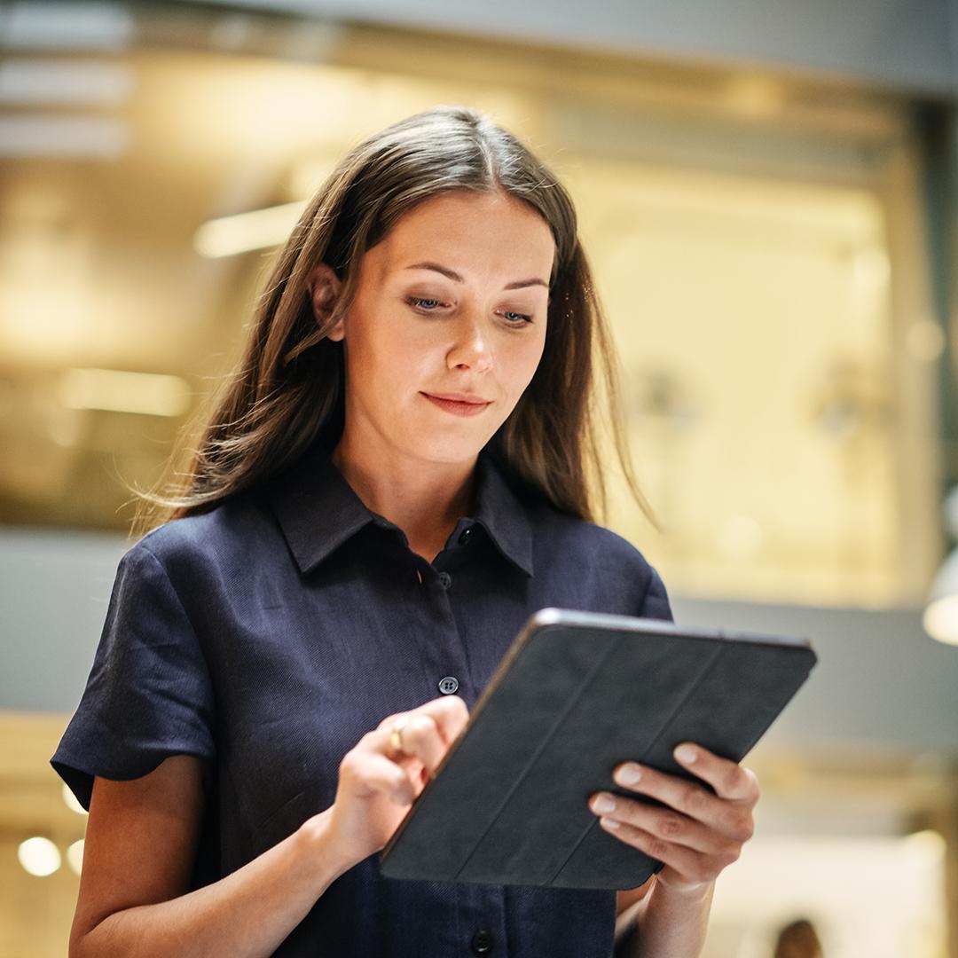 Eine Frau, die konzentriert auf ihr Tablet schaut